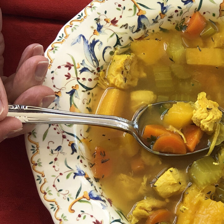 hand dipping a spoonful of Camino Chicken Vegetable Soup