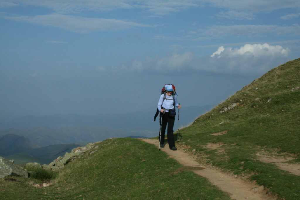 Helen walking on the Camino with the Pyrenees mountains in background