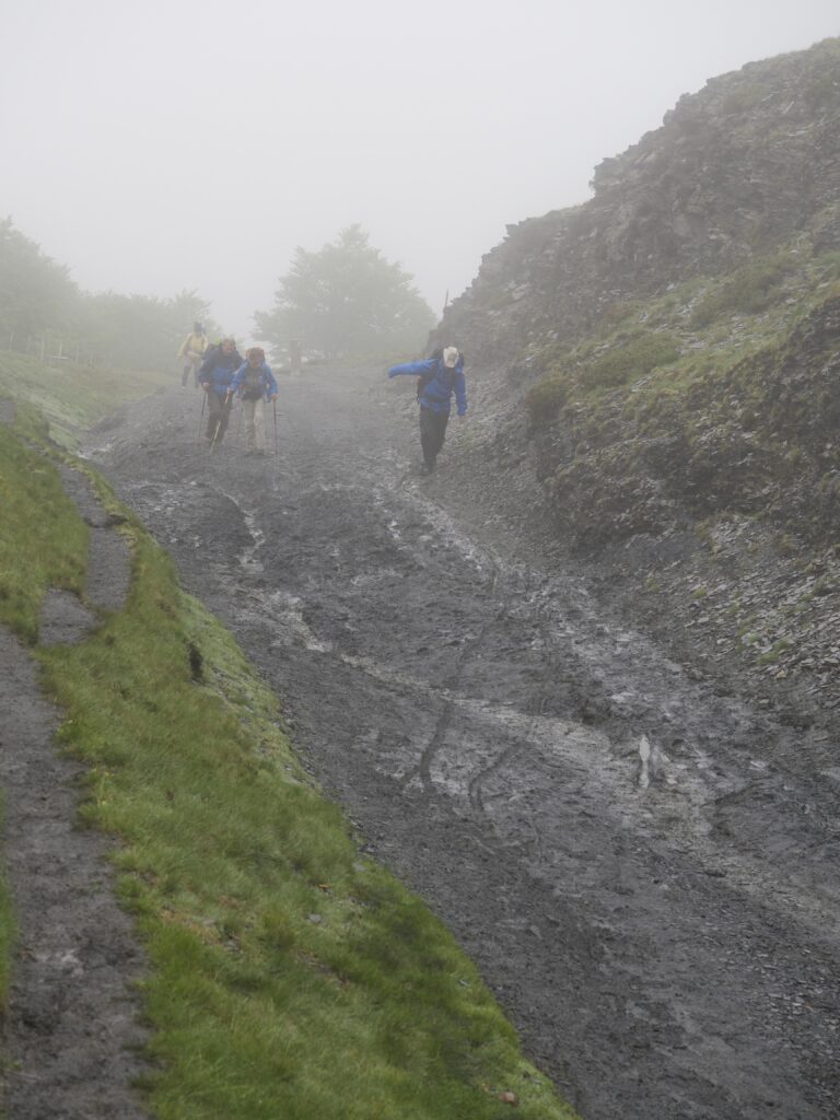 hikers walking on a muddy path in the Pyrenees