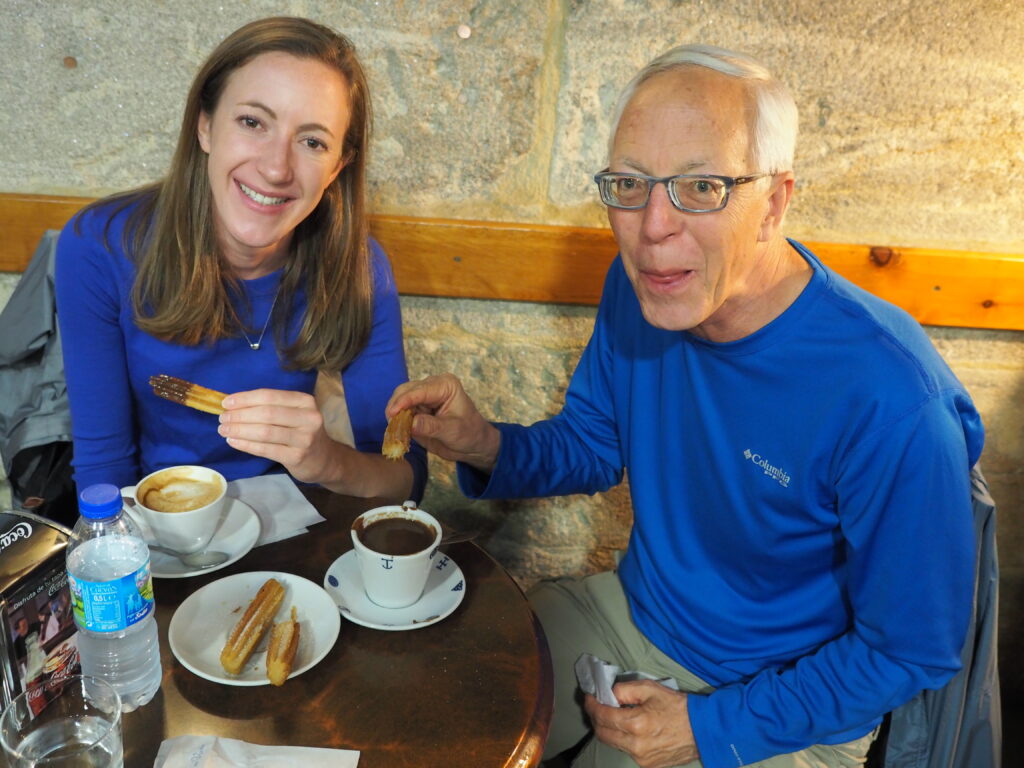 Woman and man eating Chocolate con churros are enjoying Santiago 