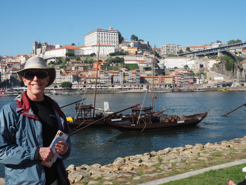 Wick in hiking clothes standing in front of Porto cityscape