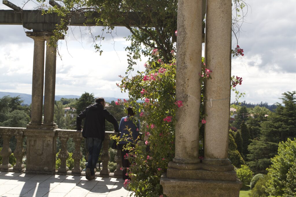 two people standing at an overlook in Alameda Park with columns and blooming flowers show one way to enjoy Santiago