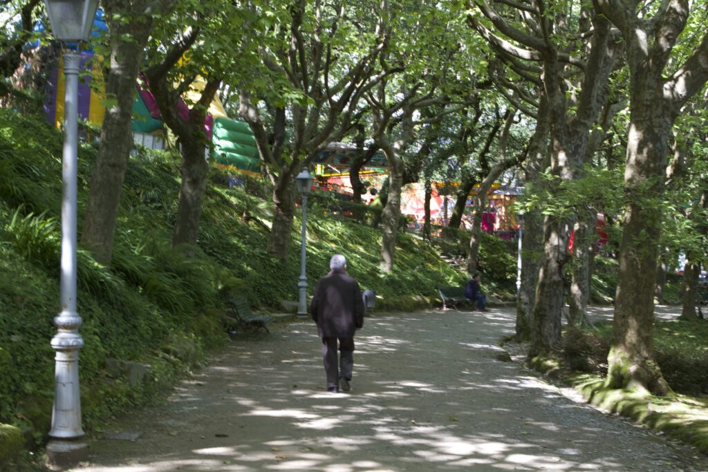 Enjoy Santiago like this man walking along a path under shady trees in Alameda Park