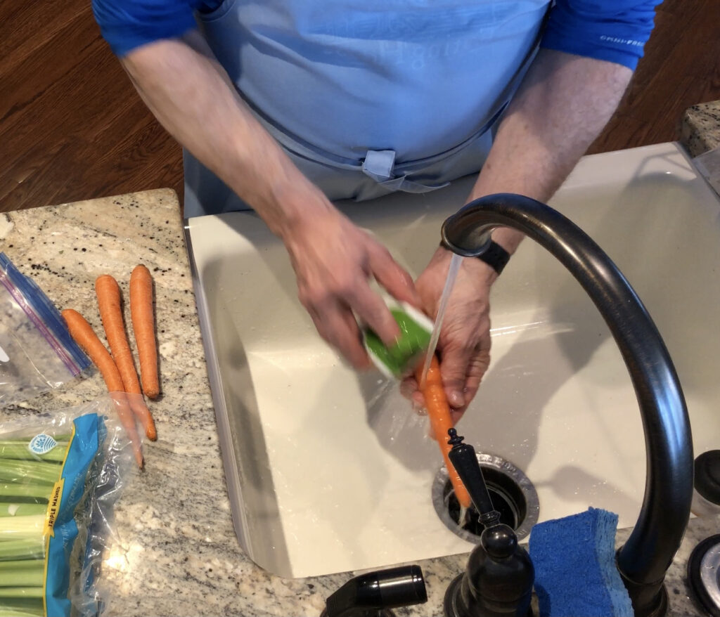 Wick's hands washing carrots for the Camino-inspired chicken vegetable soup