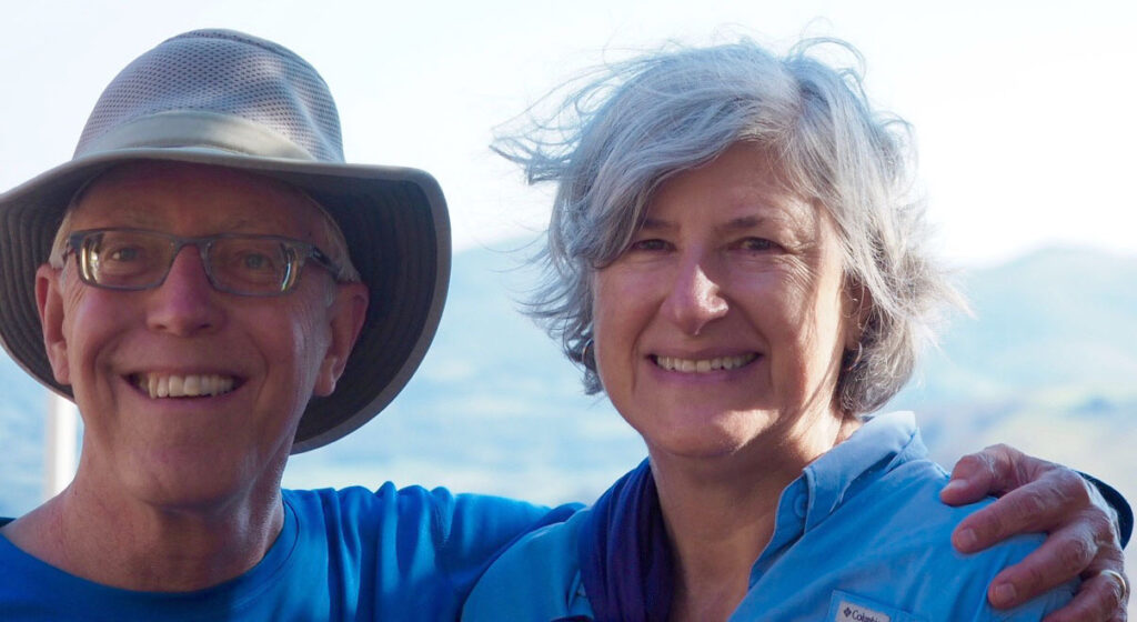 Wick and Helen in hiking clothes at the overlook in Orisson with Pyrenees mountains