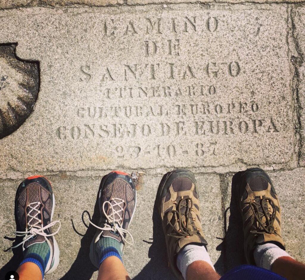 Hunter and Stephie's feet near the carved foot stone in the Santiago cathedral plaza