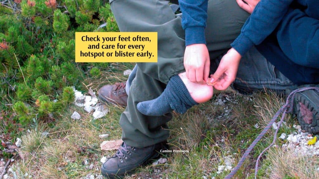 hiker putting bandage on foot blister Camino de Santiago Camino Provisions