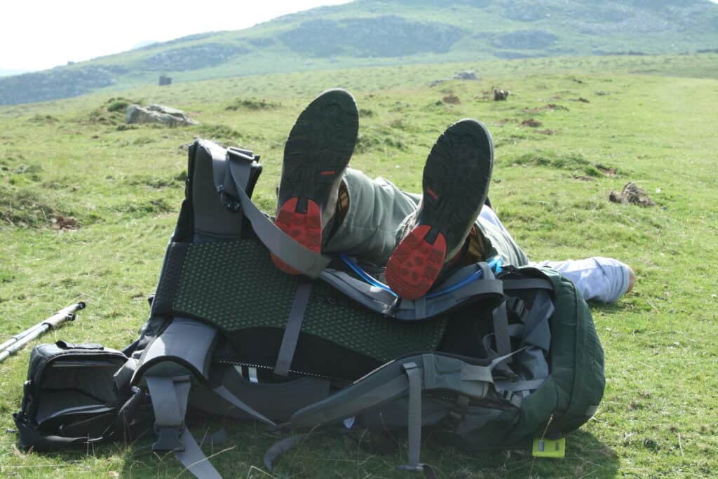 Camino hiking shoes on the Camino propped up on backpack Camino Provisions