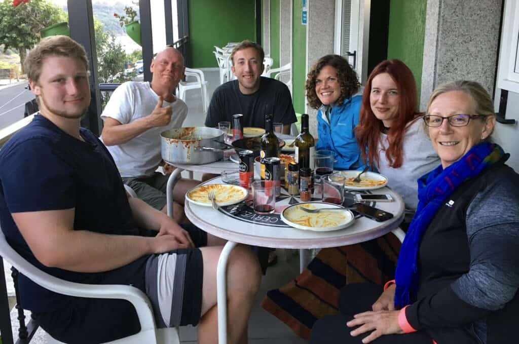 group of Camino pilgrims eat on the porch at their albergue